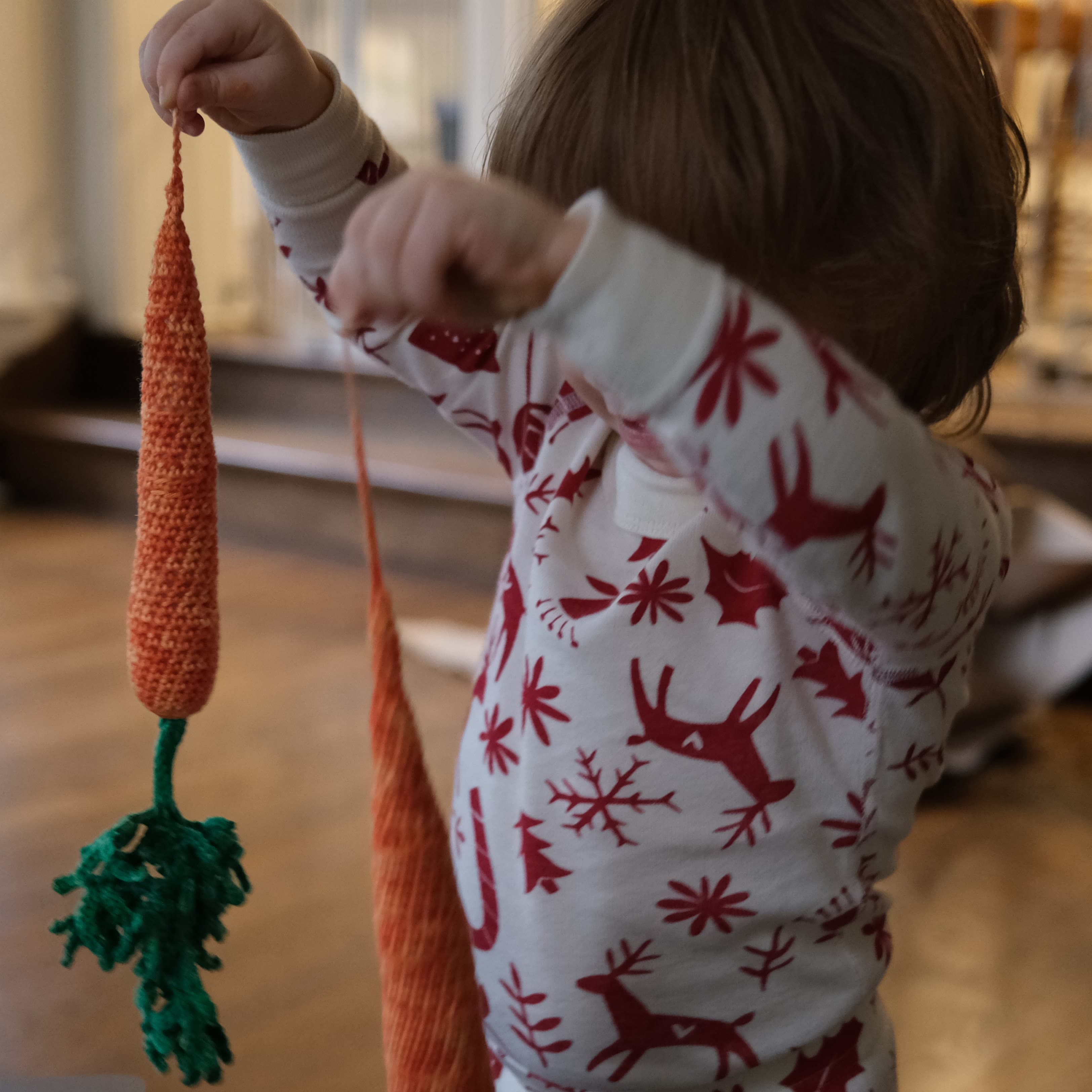 Daughter holding crochet carrot toys